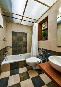 a bathroom with a tub and a toilet and a sink at Meritas Crystal Resort in Lonavala