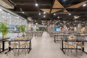 a dining hall with tables and chairs at HOTEL HIGHWAY KING Bilaspur in Manesar