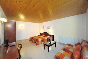 ein Hotelzimmer mit einem Bett und einem Sofa in der Unterkunft Mas Espuella in Argelaguer