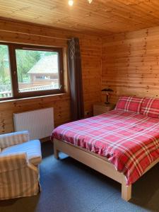 sypialnia z łóżkiem i oknem w kabinie w obiekcie Fir Tree Lodge w mieście Blairgowrie