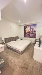 a bedroom with a large bed and a painting on the wall at راحتي هوم in Al Rass