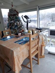 a table with a christmas tree in a room at Les écureuils bourguignons in Montchanin