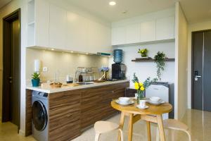 a kitchen with a washing machine and a table at Marigold Apartment Nava Park Central BSD in Tangerang