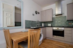 a kitchen with a wooden table and a sink at Sunshine On Leith Apartment in Edinburgh +17 photos