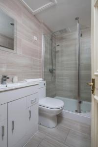a white bathroom with a toilet and a shower at Sunshine On Leith Apartment in Edinburgh