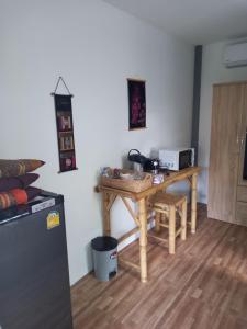 a kitchen with a wooden table with a microwave at bungalow independant in Srithanu