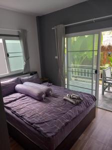 a bed with a purple comforter in a bedroom at sweet home phangan n5 in Srithanu