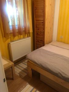 a small bedroom with a bed and a window at Örökzöld Apartmanok Balatonfenyves in Balatonfenyves