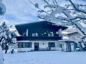une maison avec de la neige devant elle dans l'établissement Ferienhaus Plattner, à Lienz
