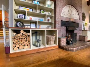 a fireplace in a living room with a shelf of logs at Glaramara Hotel in Borrowdale