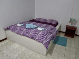 a bedroom with two beds and a purple blanket at Kwarts Appartementen in Paramaribo +73 photos