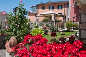 un giardino con fiori rossi di fronte a un edificio di Il Giardino di Mary a Rieti
