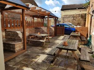 a patio with wooden benches and a wooden pergola at The Westgate in Bury Saint Edmunds