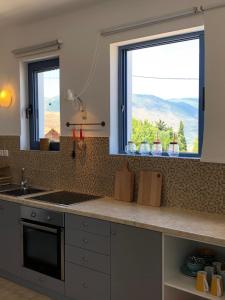 cocina con fregadero y ventana con vistas en Villa Thea - Τhe View 1st floor, en Áno Yerakaríon