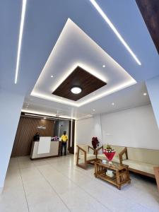 a living room with a coffered ceiling and a table at Darshan Executive in Kolhapur