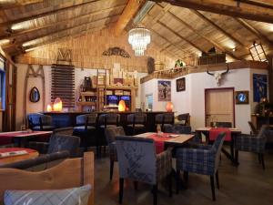 a restaurant with tables and chairs in a room at Hallstatt Dachstein Inn in Gosau