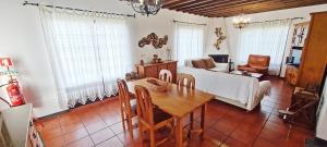 ein Wohnzimmer mit Tisch und Couch in der Unterkunft Descanso do Guerreiro in Ribeira Grande + 13 Fotos