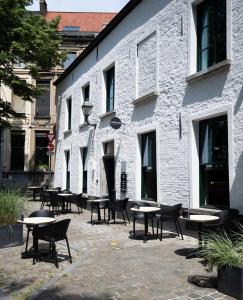a group of tables and chairs in front of a building at Nonam Boutique Hotel Gent in Ghent