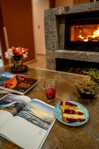 a table with a book and a piece of cake on a table with a fireplace at Calafate Apart Hotel in Coihaique