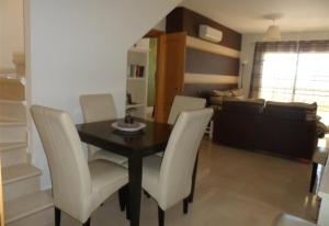una sala da pranzo con tavolo e sedie bianche di Luxury Apartment Holiday Rental Ne a Nerja