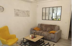 a living room with a couch and a table and a mirror at Cosy Stay in Saint-Germain-en-Laye +1 photo