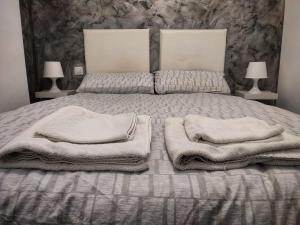 1 dormitorio con 1 cama con toallas en GR CANTERAS BEACH, en Las Palmas de Gran Canaria