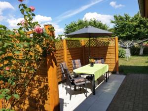 フェルトベルクにあるFerienwohnung Feldberger Seenのパティオ(パラソル付きのテーブルと椅子付)