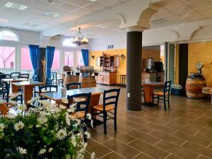 uma sala de jantar com mesas, cadeiras e flores em Hotel Stara šola - Oleander Resort em Izola