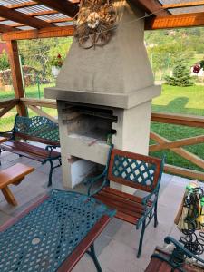 un patio con 2 panche e un forno all'aperto di Chata Aurelia a Nová Baňa