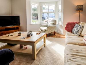 a living room with a couch and a coffee table at 4 Llain yr Eglwys in Newport Pembrokeshire