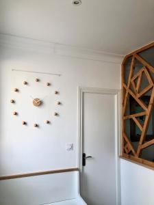eine Uhr an einer Wand neben einer Tür in der Unterkunft Bel appartement rénové, centre de Vannes in Vannes
