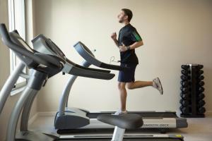 a man running on a treadmill in a gym at Regency Way Montevideo Hotel in Montevideo