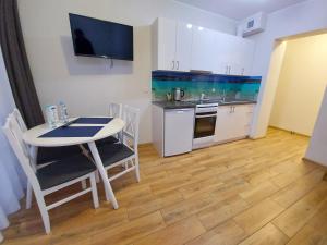 a small kitchen with a table and a table and chairs at Apartamenty Kapitanskie in Iława