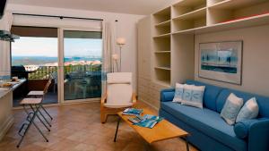 a living room with a blue couch and a balcony at Residence Floreal in San Pasquale