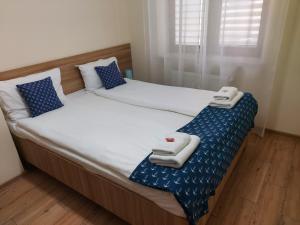 two twin beds in a room with towels on them at Apartamenty Kapitanskie in Iława