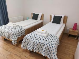 2 łóżka pojedyncze w małym pokoju z: w obiekcie Apartamenty Kapitanskie w Iławie