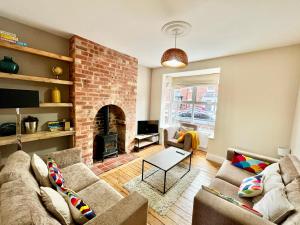 a living room with two couches and a brick fireplace at Cecil Street in Lincoln