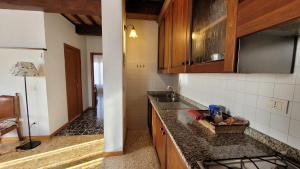 een keuken met een wastafel en een aanrecht bij Finestra sulla val d'Orcia in San Quirico dʼOrcia