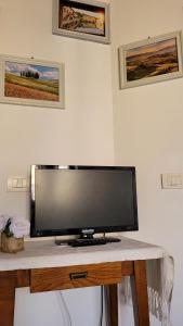 TV de pantalla plana en la parte superior de una mesa en Camera La Margherita en San Quirico dʼOrcia