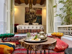 una sala de estar con una mesa con una tetera. en BCK Art Riad en Marrakech