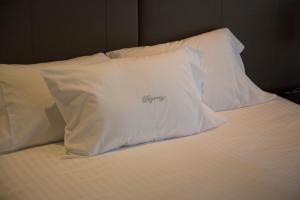 a bed with white pillows on top of it at Regency Way Montevideo Hotel in Montevideo