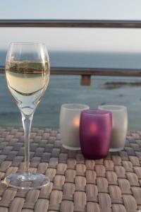 a glass of wine sitting on a table with candles at Atlantic Hôtel & Spa in Les Sables-d'Olonne