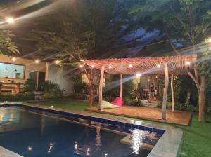 a pergola over a swimming pool at night at Krisna Bungalows and Restaurant in Sekotong