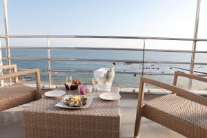 a table with a plate of food and a bird on a balcony at Atlantic Hôtel & Spa in Les Sables-d'Olonne