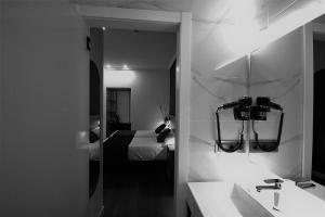 a bathroom with a sink and a bed and a mirror at Hotel BH San Francisco Alicante in Alicante