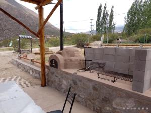 un patio con un horno de pizza con mesa y sillas en Cabañas Comarca de la Quebrada en Potrerillos