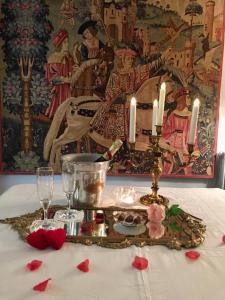 uma mesa com uma toalha de mesa com velas e rosas vermelhas em Château Ratou em Saint-Lys