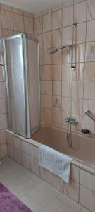 uma casa de banho com um chuveiro e uma banheira com uma toalha em Ferienwohnung Seeberg mit Almfeeling em Faistenau