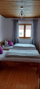 Ferienwohnung Seeberg mit Almfeeling في فيستينو: سريرين في غرفة نوم مع أرضية خشبية
