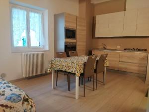 cocina con mesa y sillas en una habitación en Appartamenti Il Cerbiatto, en Cavedago